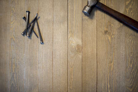 An overhead shot of hammer and nails on a wooden surfaceの写真素材