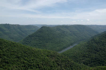 A beautiful landscape shot of a breathtaking green mountain valley with a river flowing through.