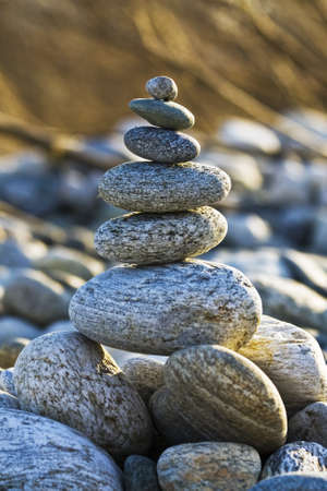 A vertical shot of stones balancing on each other with a blurred backgroundの写真素材