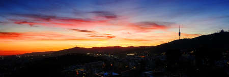 A panorama shot of a beautiful city under the sunset in a colorful sky