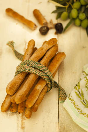 A vertical closeup shot of tied breadsticks on a wooden surfaceの写真素材