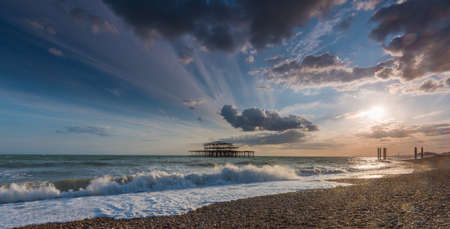 The beautiful foamy waves of the sea coming to the shore under the amazing clouds in the skyの写真素材