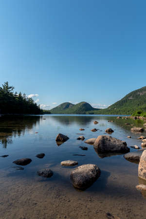 vertical shot of a lake with big stones and the reflection of the sky in itの写真素材