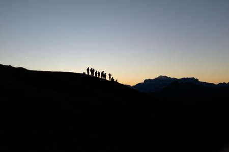A silhouette of people on the mountain with a clear sky in the backgroundの写真素材