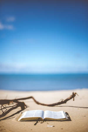 open bible on a beach shore with a blurred backgroundの写真素材