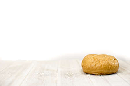 A closeup shot of a bun on a white surface - great for background