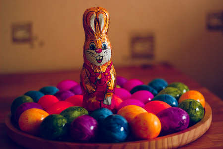 A closeup shot of bunny chocolate and Easter eggs on a tray with a blurred backgroundの写真素材