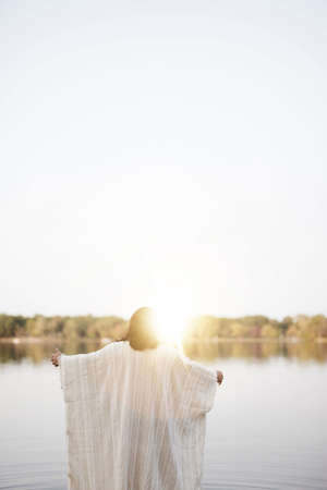 A biblical scene - of Jesus Christ with his hands up with a blurred background shot from behindの写真素材