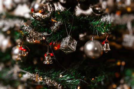 A closeup shot of a decorated Christmas tree with string lights and beautiful ornamentsの写真素材