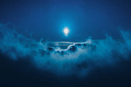 An incredible horizontal shot of the moon among thick clouds during the night. Perfect for a...