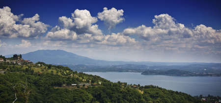 A mesmerizing shot of the beautiful seascape surrounded by green mountains under a cloudy skyの写真素材
