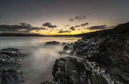 A horizontal shot of water splashing to the mountains during sunset in Cornwall, UKの写真素材