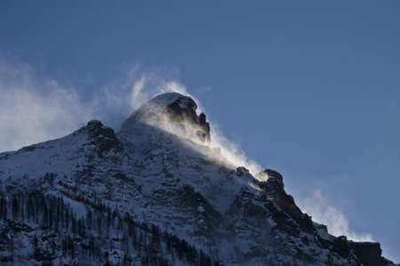 A breathtaking scenery of the snow-capped mountains under a scenic cloudy sky