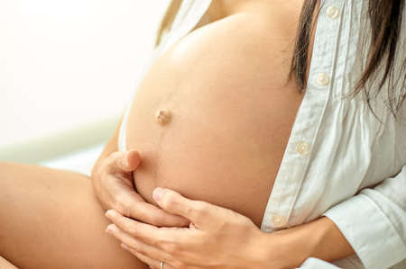 A Caucasian pregnant woman wearing a white shirtの写真素材