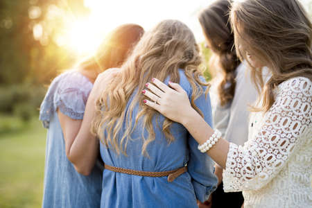 A closeup shot of female with their arms on each other while praying with a blurred backgroundの写真素材
