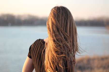 A female with standing by a lakeの写真素材