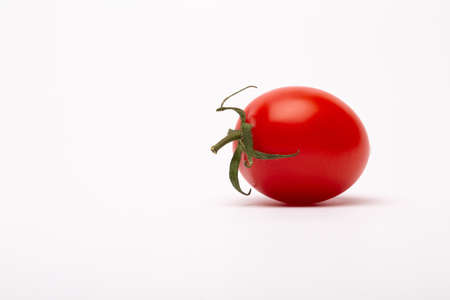 A closeup shot of a cherry tomato on a white background - perfect for a food blogの写真素材