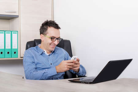 A shallow focus shot of a smiling male in a workplace