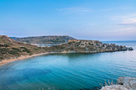 A high angle shot of a beautiful island with rocks near the calm sea under the beautiful blue skyの写真素材