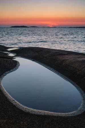 A vertical shot of the sunset on the shore of the sea in Swedenの写真素材