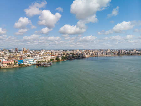 A high angle shot of the ocean by the city under the cloudy sky captured in Mombasa, Kenyaの写真素材