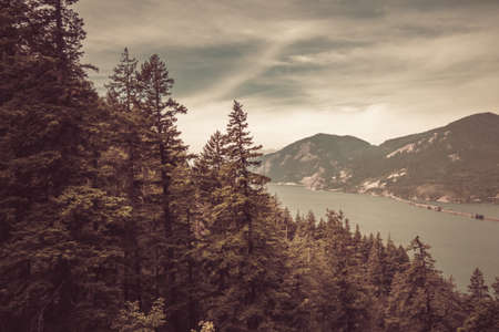 A beautiful scenery of a river in the middle of a mountainous scenery under the gloomy skyの写真素材