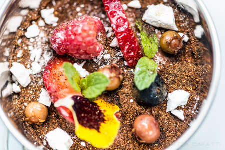 A high angle closeup shot of a decorative plate with berries and fruitsの写真素材