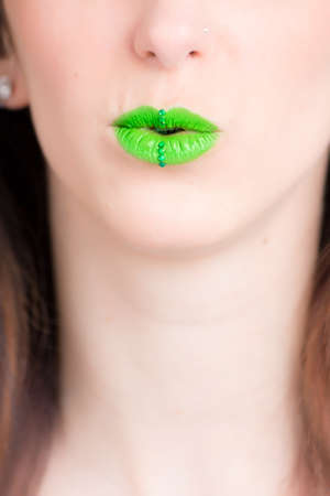A vertical closeup shot of a female wearing a green lipstick - great for an article about cosmeticsの写真素材