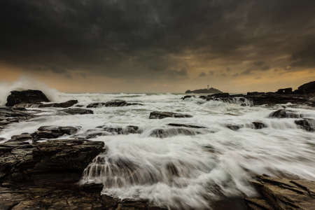 A beautiful shot of water flowing movement above rock formations under gray cloudy scenic sky