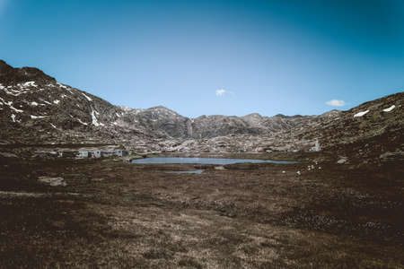 A horizontal shot of a lake surrounded by beautiful rocky mountains under the breathtaking skyの写真素材