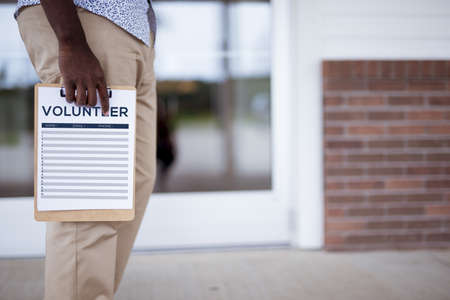 A closeup shot of a person holding a volunteer sign up sheet with a blurred backgroundの写真素材