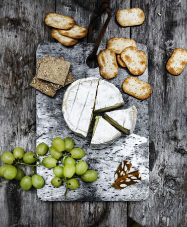A vertical shot of delicious brie cheese on a wooden deck - perfect for a food blogの写真素材