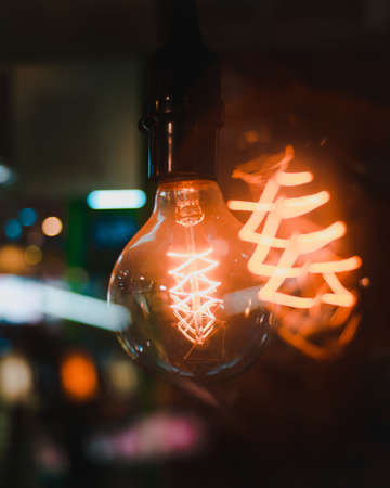 A vertical closeup shot of turned-on light bulbs with interesting textures on a blurred backgroundの写真素材