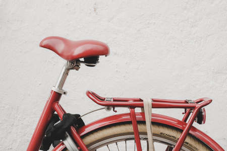 Red old bicycle saddle with white background