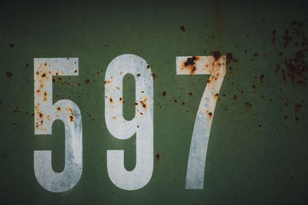 A cool closeup look of white numbers on a rusty old green metal - a good background and wallpaper