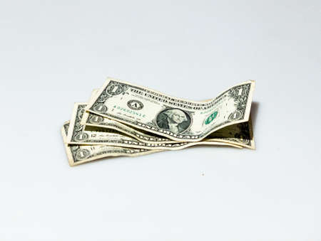 An isolated shot of a few one-dollar bills on a white background