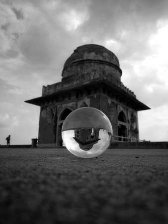 A vertical shot of a historic building in Mandav, India, reflected in a crystal ballの写真素材