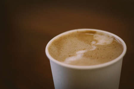 A high angle closeup shot of a white cup filled with espresso coffee - good morning concept