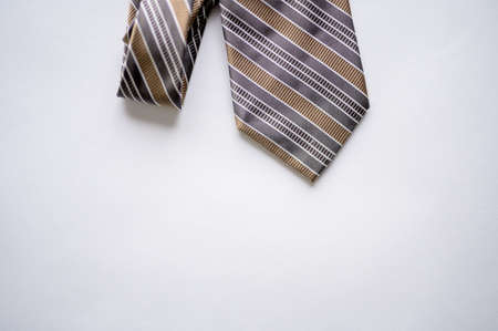 An overhead  shot of a striped tie on a white surface