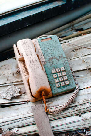 A vertical high angle shot of an old rusty telephone inside an abandoned building in Wanli UFO Village, Taiwanの写真素材