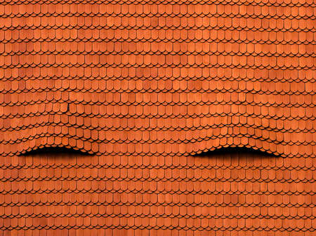 A cool background of an old red roof with interesting texturesの写真素材