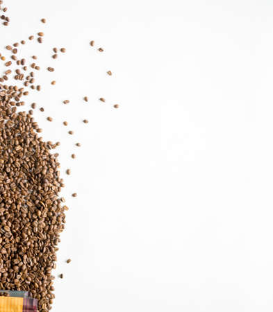 An overhead vertical shot of coffee beans on a white surfaceの写真素材