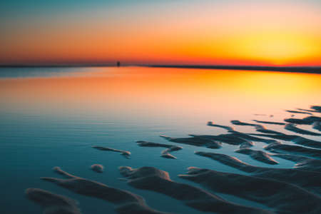 A beautiful view of the reflection of the sun in the lake captured in Vrouwenpolder, Netherlandsの写真素材