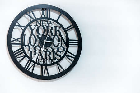 A trendy black watch on a white wall creating a minimalistic atmosphereの写真素材