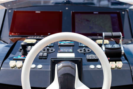 A closeup shot of the helm of a modern yacht in the captain's bridge
