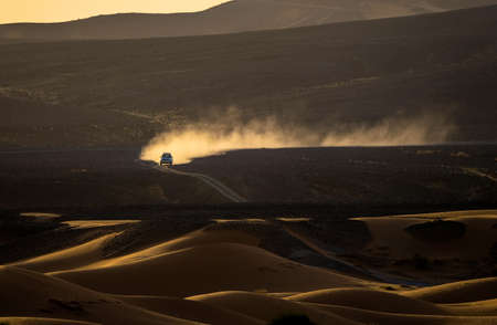 A car driving in the middle of the desertの写真素材