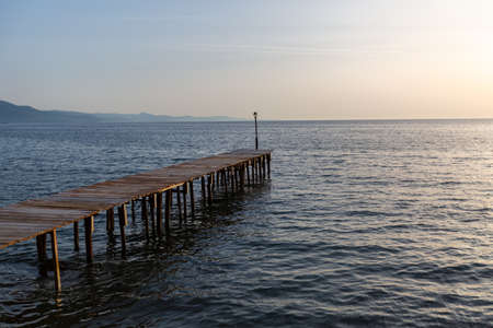 A wooden pier over the beautiful calm ocean captured in Lesbos, Greeceの写真素材