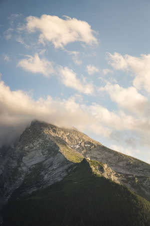 A vertical shot of the last golden light of the sun touching the Watzmann mountain in Berchtesgaden,...