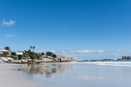 A beautiful shot of a surfing desk on the ocean shore on a bright sunny dayの写真素材