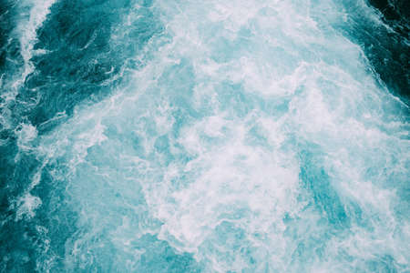 A high angle shot of the foamy waves of the ocean